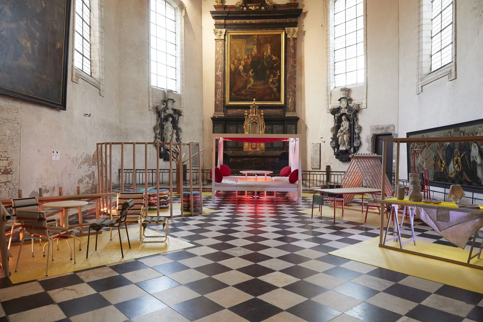 La nef de la chapelle de l'Hospice Comtesse pendant l'exposition finale : les projets installés sur des tapis jaunes, le sol en damier noir et blanc.