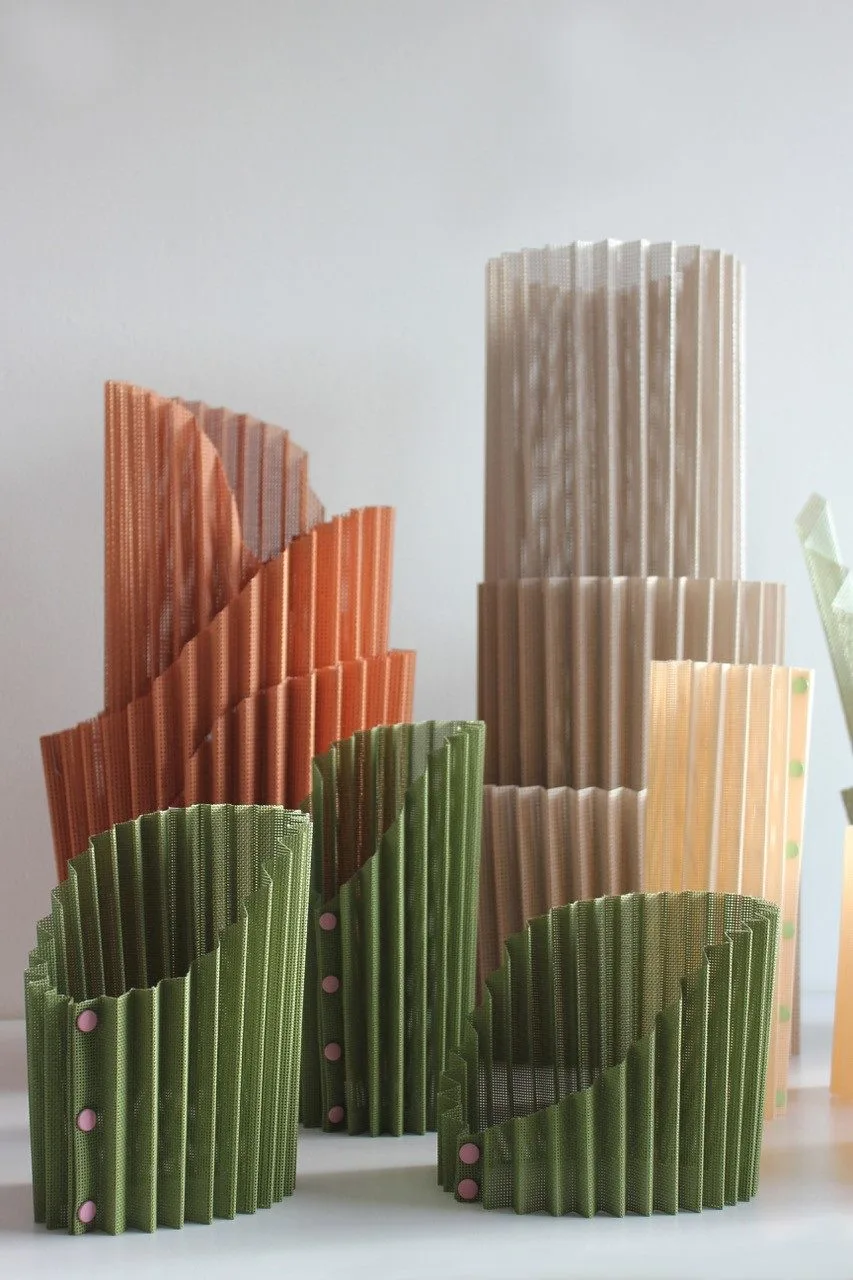 Modules pliés en carton vert et orange du projet DÉPLI, déployés en corolle.