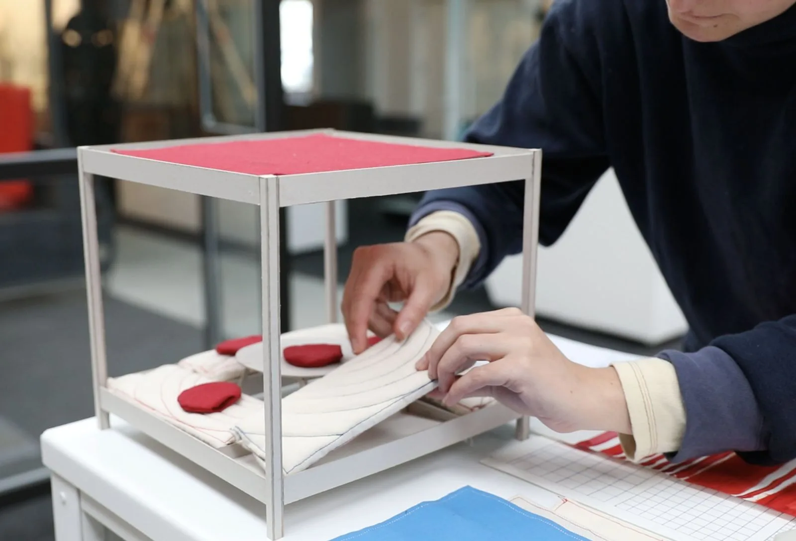 Maquette de la structure à l'échelle réduite, manipulée sur un plan de travail.