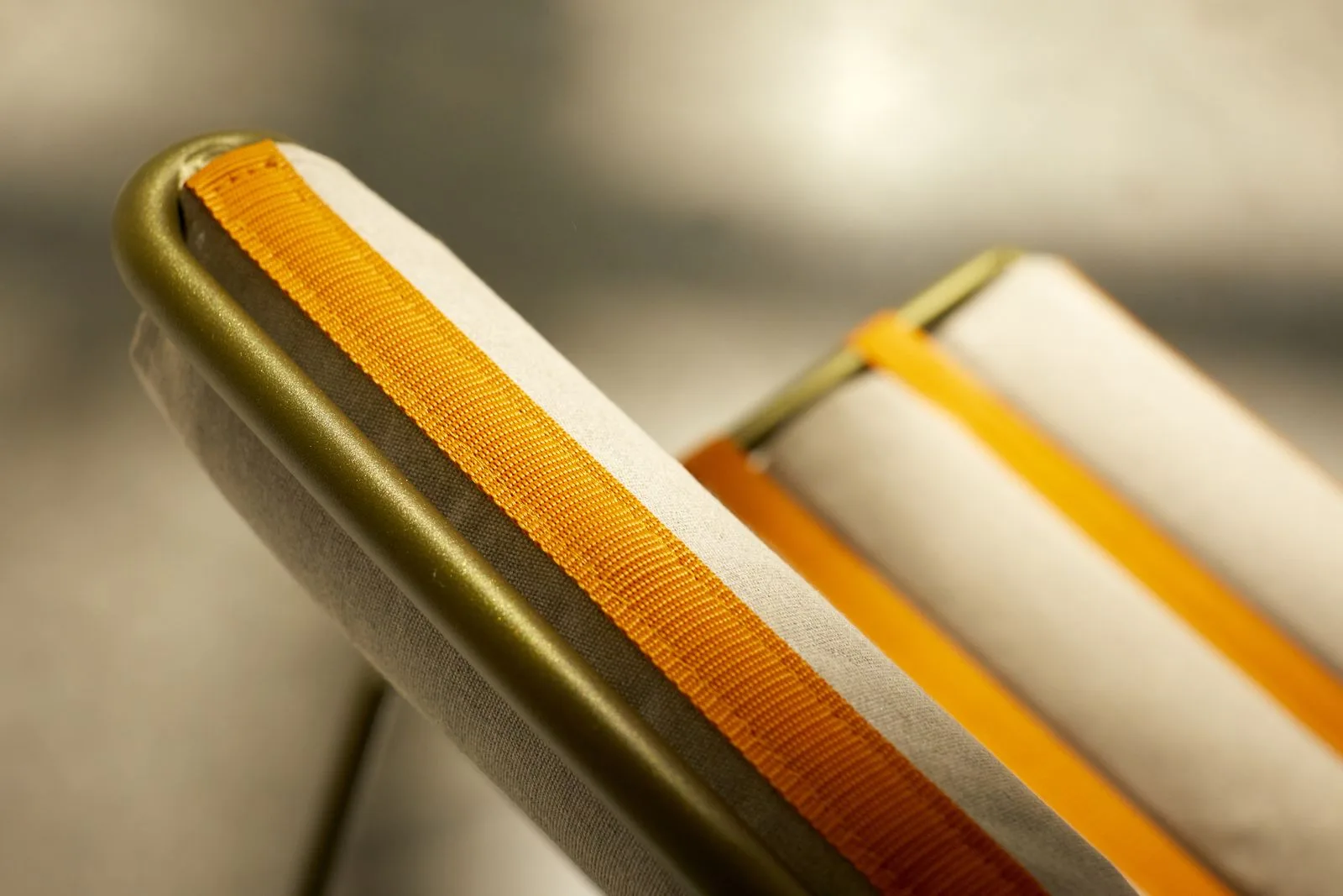 Gros plan sur une sangle orange tendue le long de l'accoudoir.