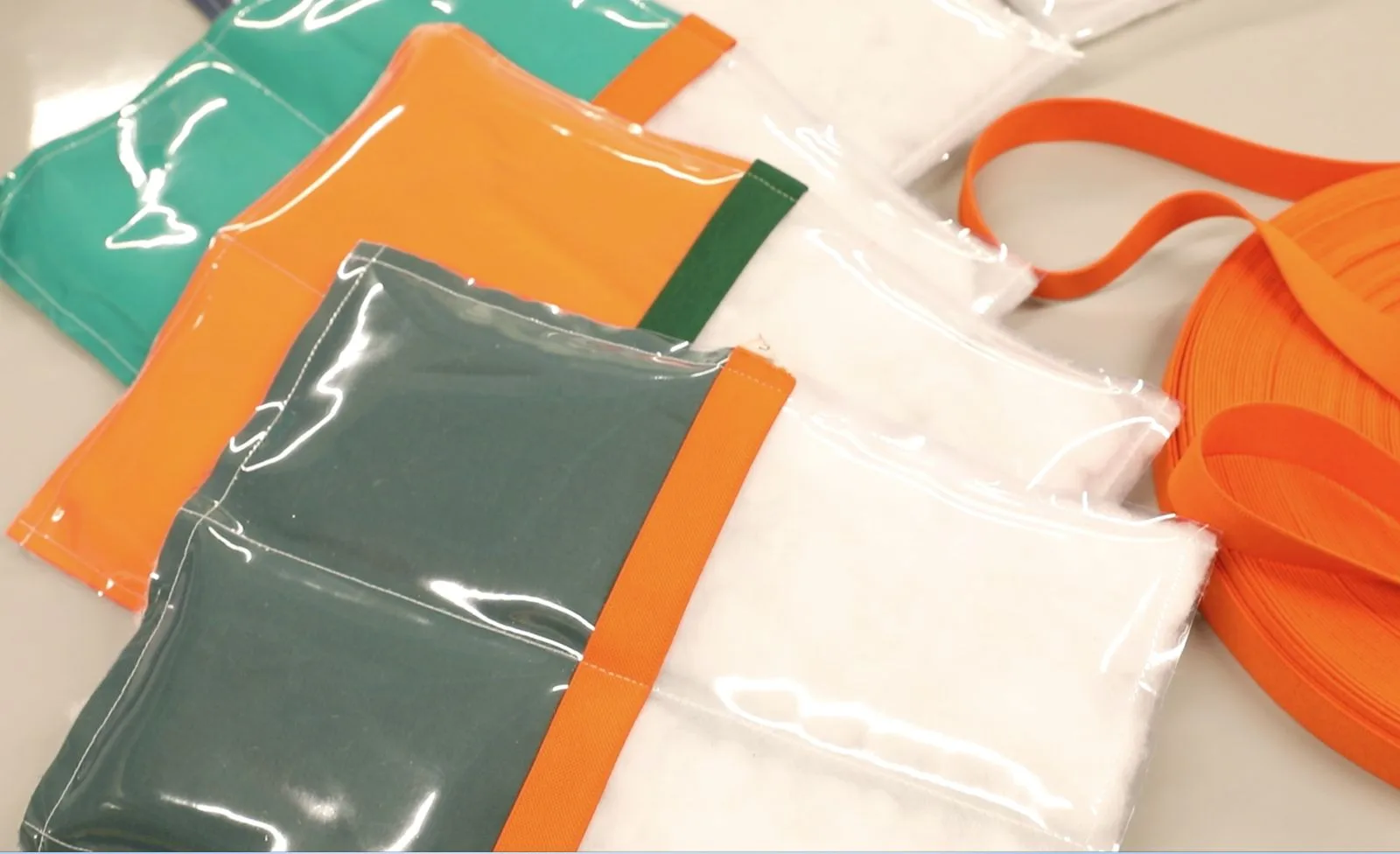 Pièces découpées vertes, orange et transparentes, prêtes à être assemblées.
