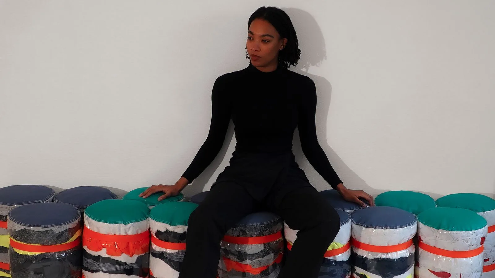 Une personne assise sur l'alignement d'assises cylindriques, en situation.