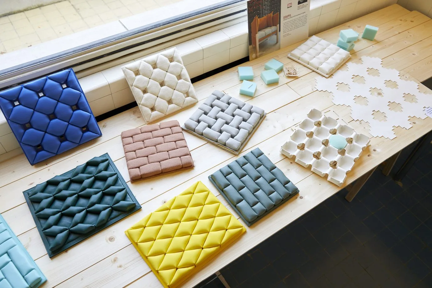 Échantillons de panneaux acoustiques matelassés du projet GOUPIL, alignés sur une table.