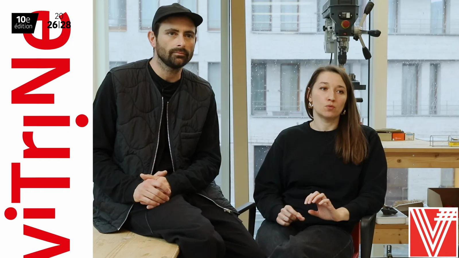 Luis Bellenger et Pauline Capdo assis côte à côte dans leur atelier, devant un établi et une perceuse à colonne.